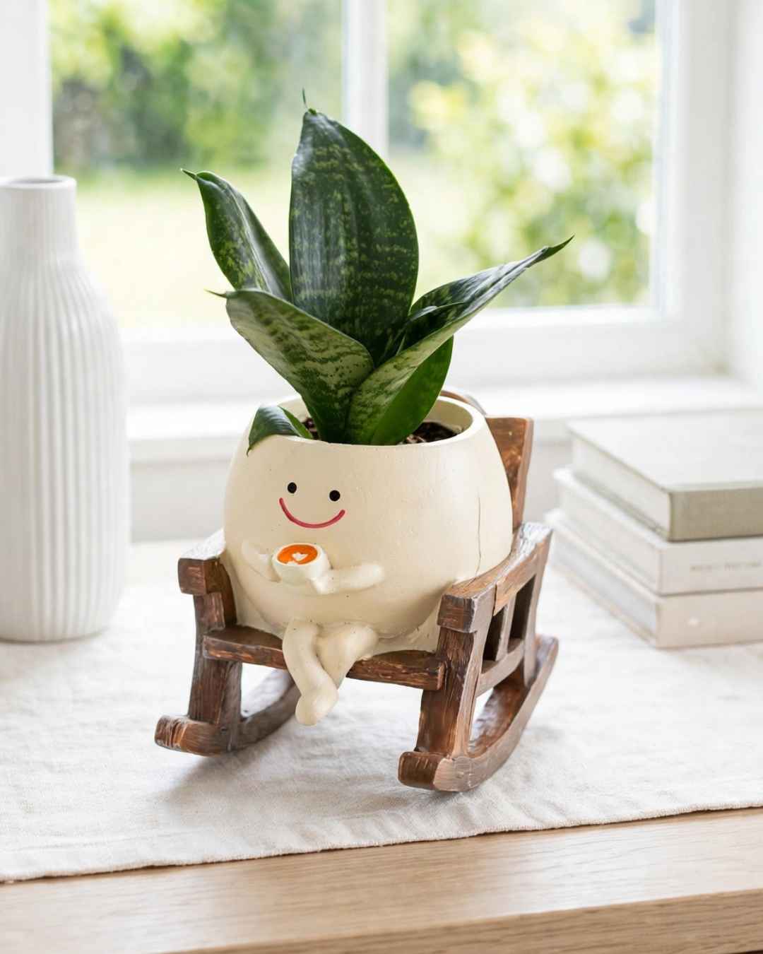 Maceta sonriente  en mecedora con café